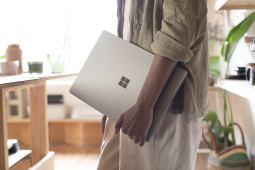 Person holding a Surface Laptop with left arm. Source Microsoft.